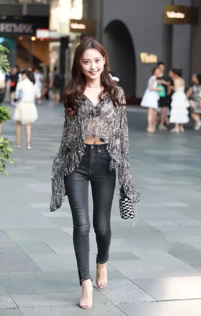 紧身牛仔裤的美女，搭配薄如纱的上衣，美丽又大方，很招人喜欢！