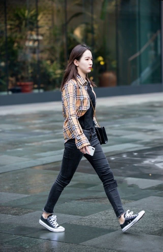 【牛仔裤】街拍:五官精巧的美女,格子衬衫搭配黑色牛仔裤,看起来休闲又不失气质