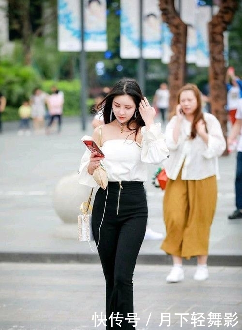  美女■街拍：俏丽的美女一款简约的黑色连衣裙大方美丽，长发轻舞飞扬更是散发出别样魅力