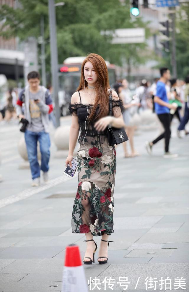 街拍：身穿薄纱吊带衣的小姐姐，胸前还开一个小口，美的很有别致
