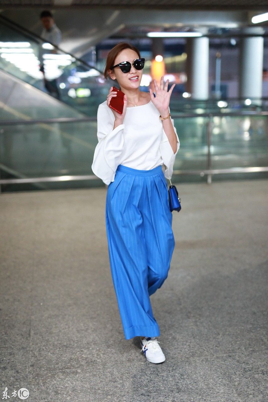 叶一茜穿白色喇叭袖上衣搭配蓝色阔腿裤现身机场,戴墨镜心情佳!