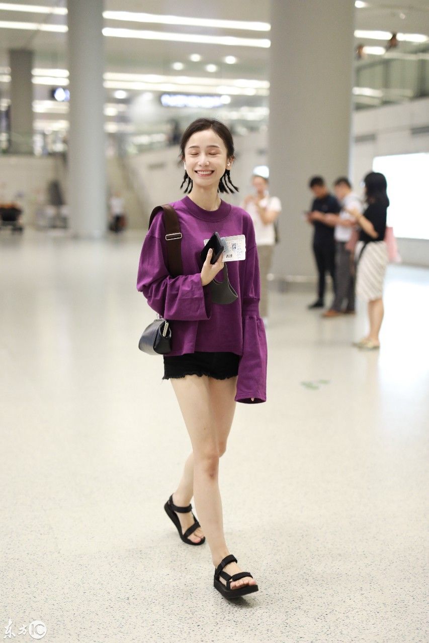 姜梓新穿紫色卫衣搭配黑短裤现身机场，皮肤白皙面带微笑大秀美腿