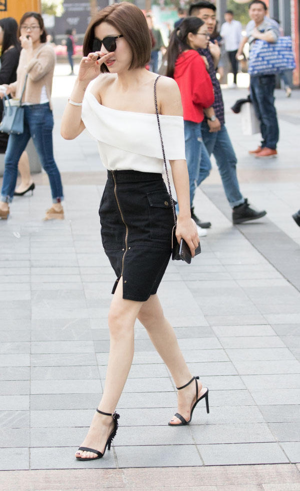 气质小姐姐低胸上衣显出白嫩香肩，黑色包臀裙勾勒出迷人的大长腿