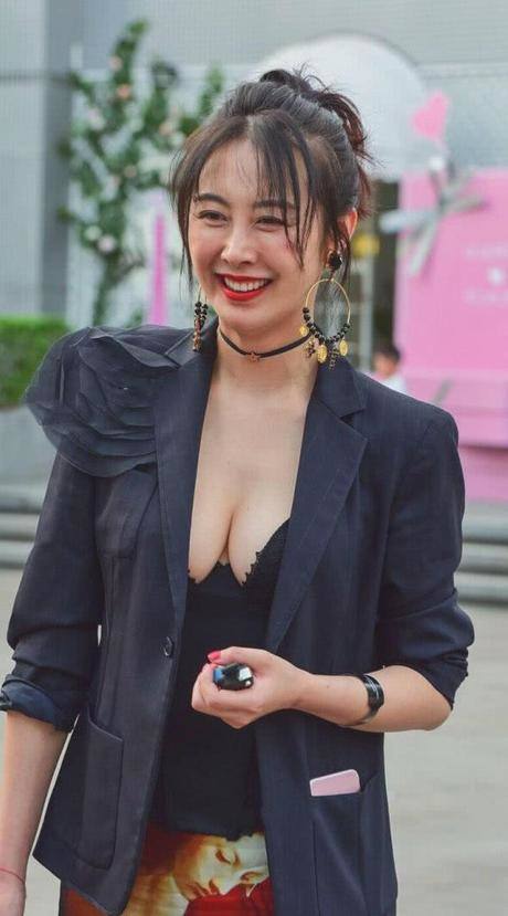 时尚御姐穿黑色深V领上衣秀出丰腴饱满的上围曲线，傲人上围很吸