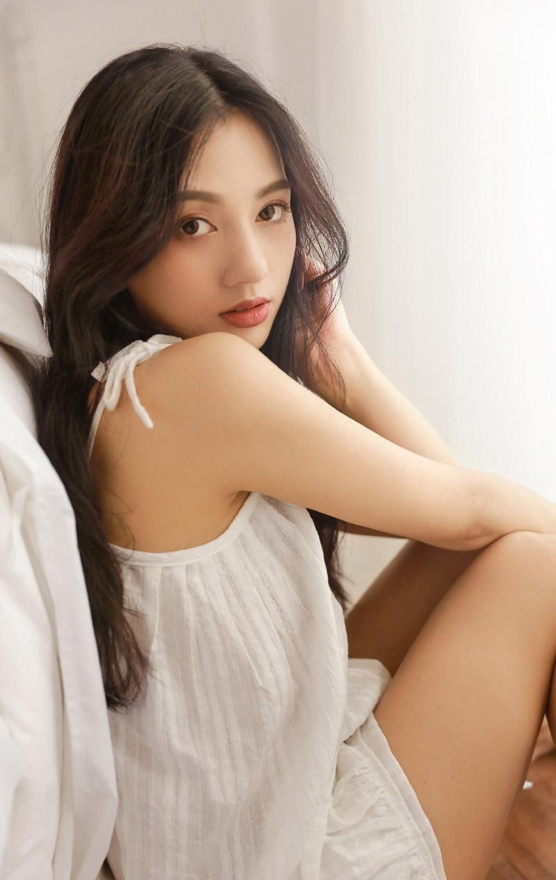 吊带裙美女性感慵懒床上写真图片