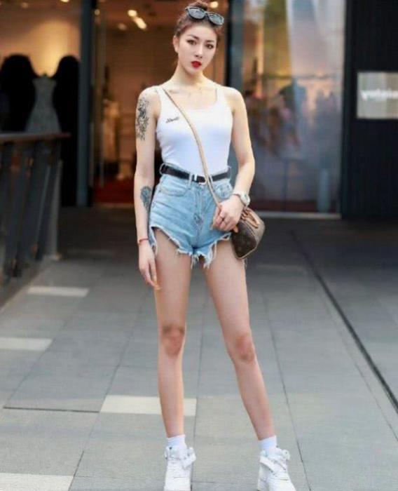 美女■街拍:头上架一副太阳镜的美女,吊带背心搭配热裤,帅气大方显腿长