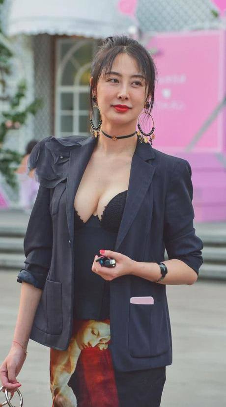 时尚御姐穿黑色深V领上衣秀出丰腴饱满的上围曲线，傲人上围很吸