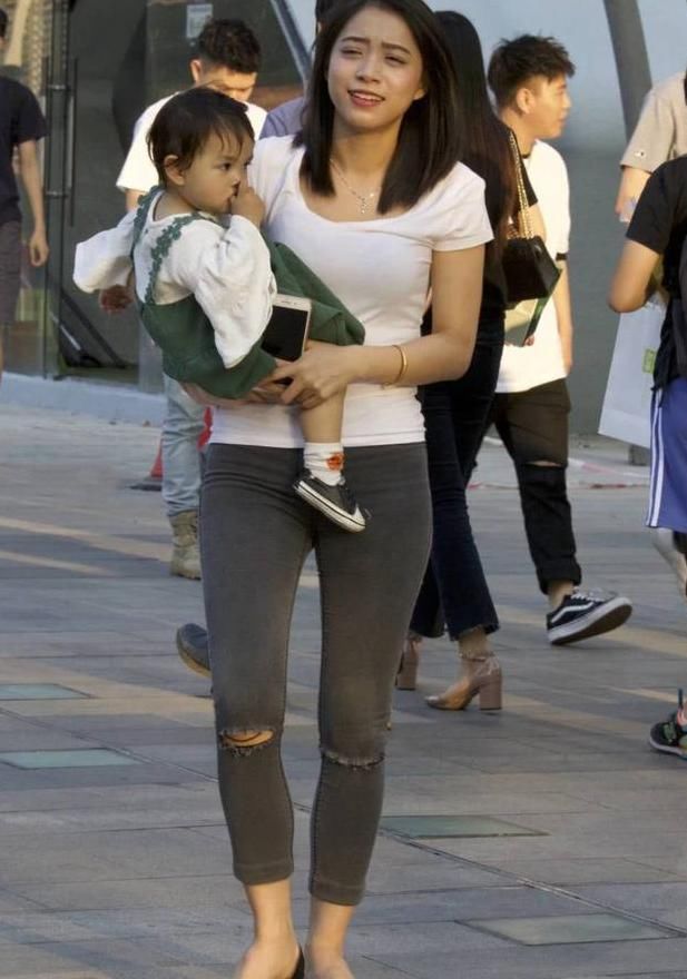 街拍美女：白色的t恤搭配黑色的紧身牛仔裤，辣妈身材很耐看