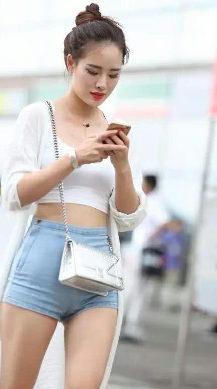 街拍：气质小姐姐丸子头呆萌可爱，紧身牛仔短裤绷出完美臀线