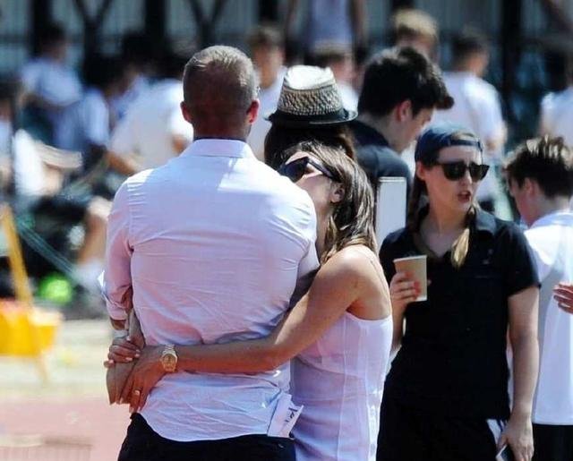 贝嫂用双臂搂住贝克汉姆的腰，凝视着小贝的眼睛，感情全在眼神里