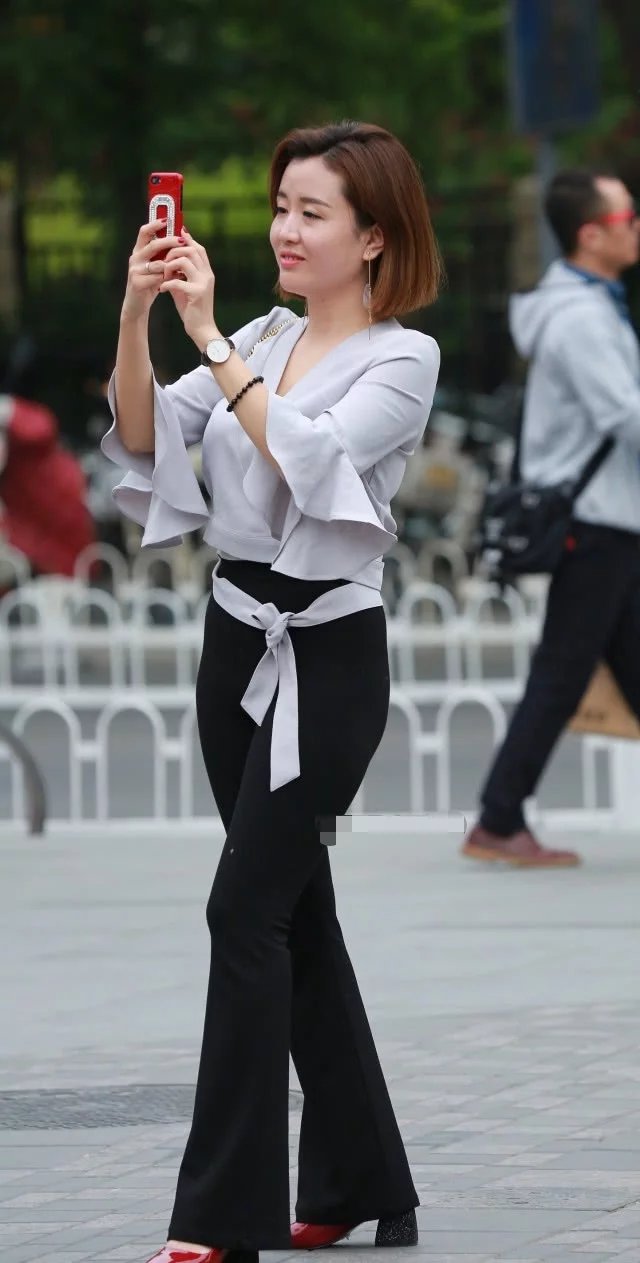 时尚美女小姐姐黑色紧身裤搭配白色上衣，修身的装扮秀出凹凸有致