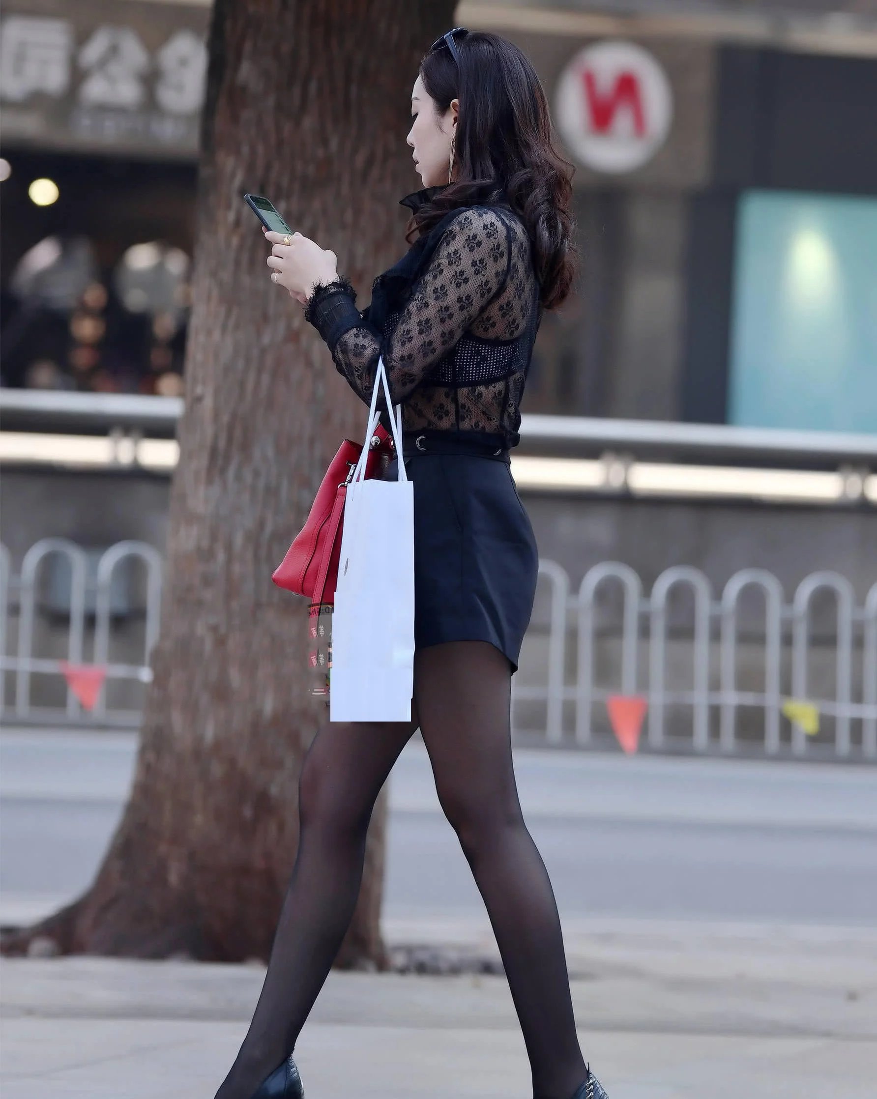 小姐姐穿着黑色蕾丝的上衣，黑色的超短裙搭配一条黑色的丝袜，黑