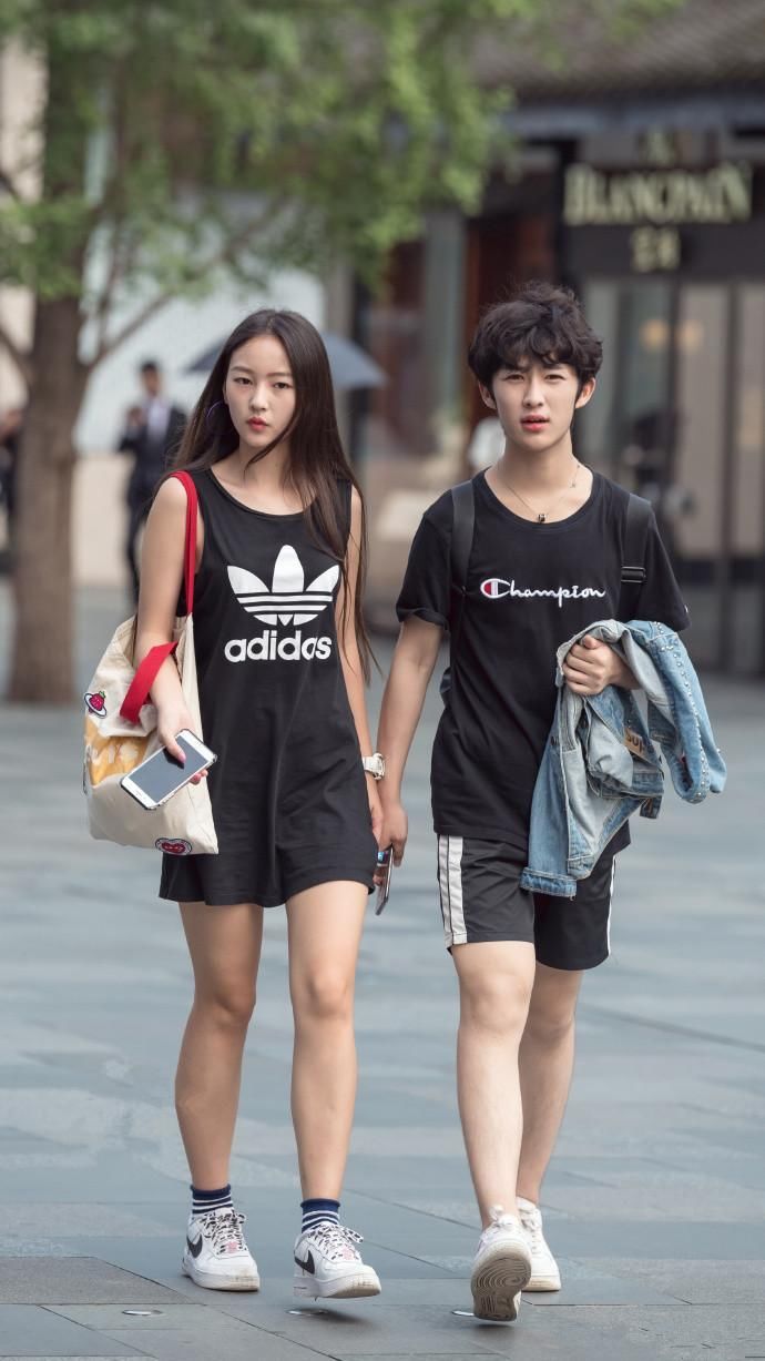 街拍:大波浪卷的小姐姐专心玩手机，双腿笔直又修长，太美了!