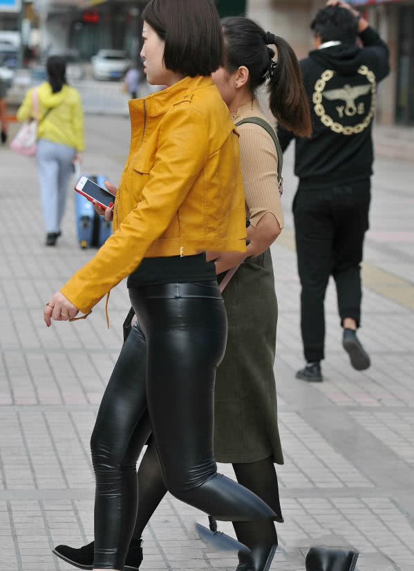 紧身皮裤小姐姐搭配黄色衬衫，弯腰的瞬间展露丰满的曲线，很有看