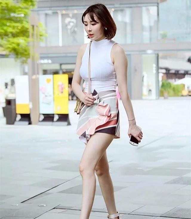 路人街拍，小姐姐穿着白色的背心连衣裙，很是清新纯洁