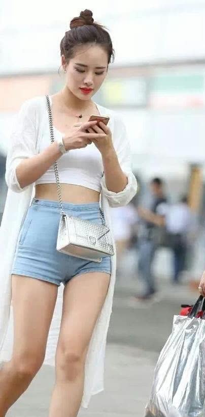 街拍：气质小姐姐丸子头呆萌可爱，紧身牛仔短裤绷出完美臀线