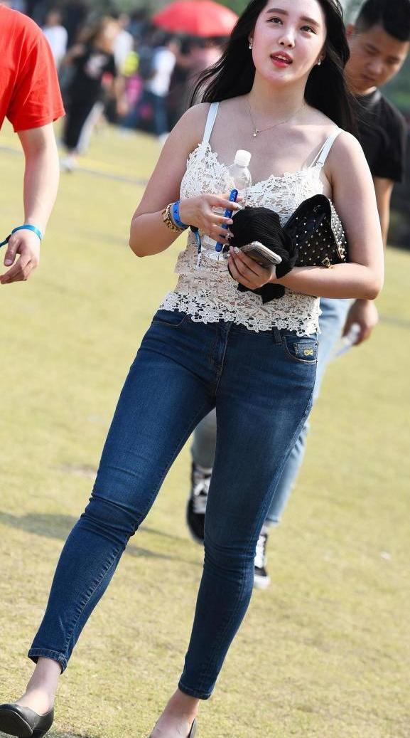 时尚街拍：穿紧身牛仔裤的美女，小背心您觉得如何？