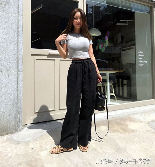 模特一袭灰色T恤配黑色阔腿裤简约时尚，气质清冷不苟言笑