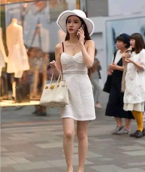 美女一身蓝色吊带背心，显示出自己的胸围，很性感！