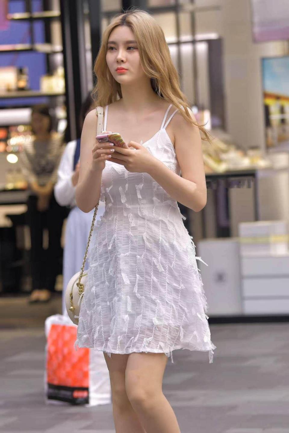 路人时尚，小姐姐身穿白色吊带连衣裙，干净又清爽