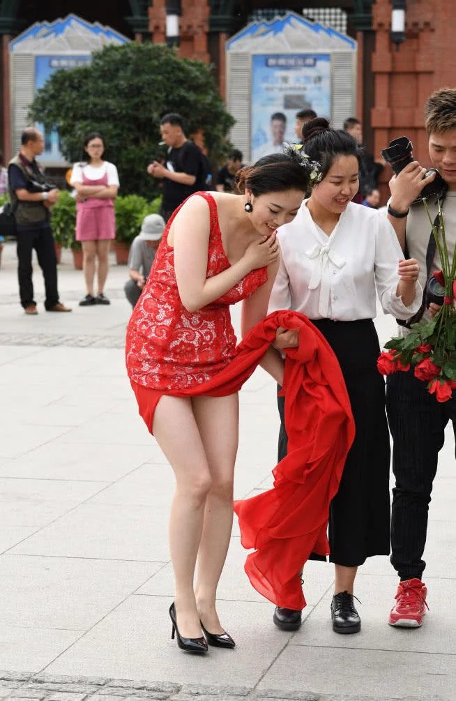 小姐姐穿红色嫁衣撩起裙摆秀出一双白皙美腿，笑容很幸福
