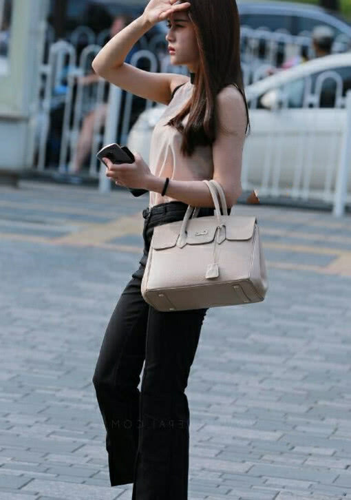 气质小姐姐黑色职业裤青春活力，一手遮阳，俏皮中带着几分可爱