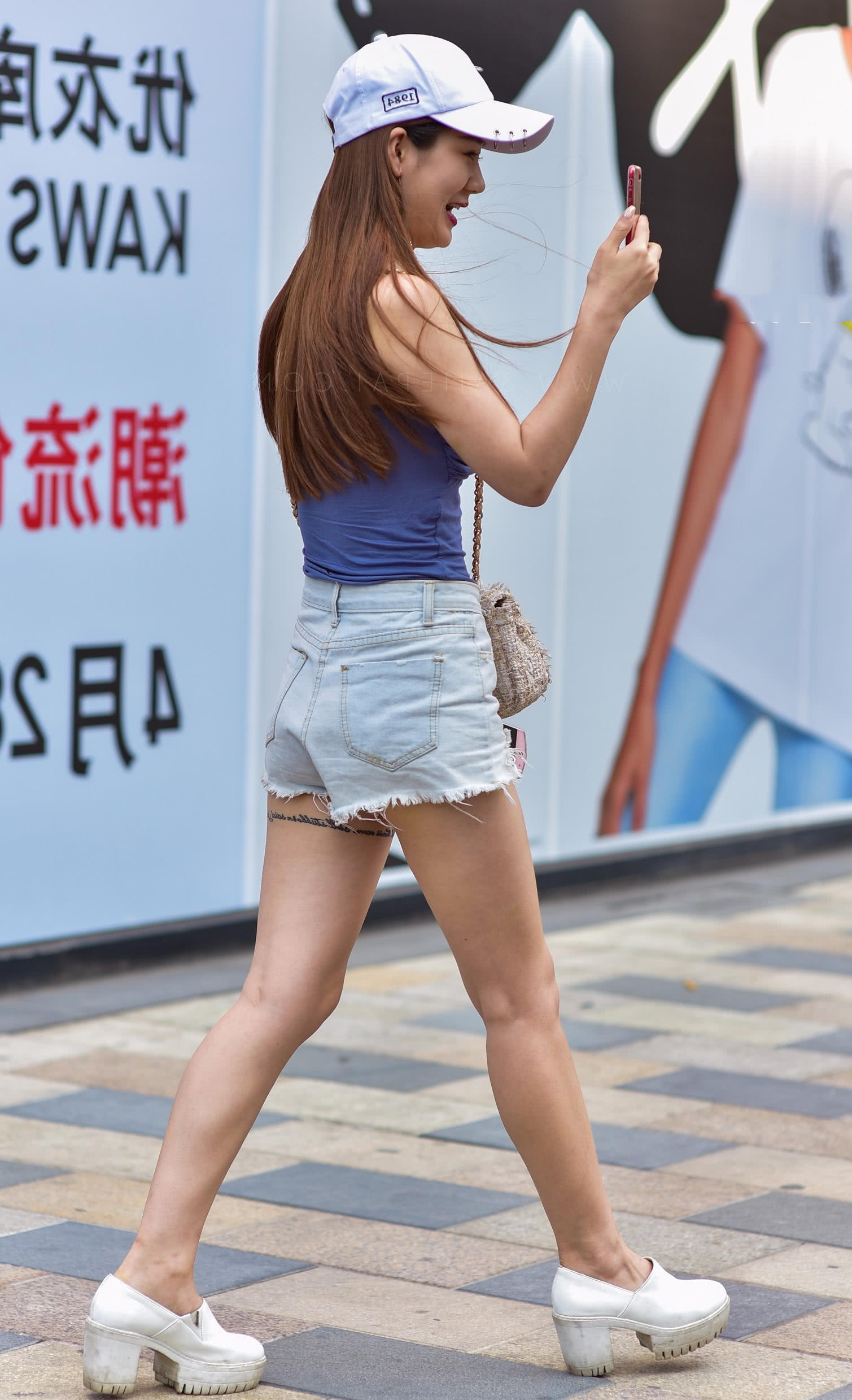 时尚小姐姐完美身材裹胸热裤，拿着两个手机和别人视频