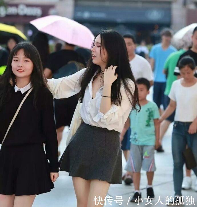 路人街拍小姐姐长T恤秀出性感美腿,精美的面孔有点像明星