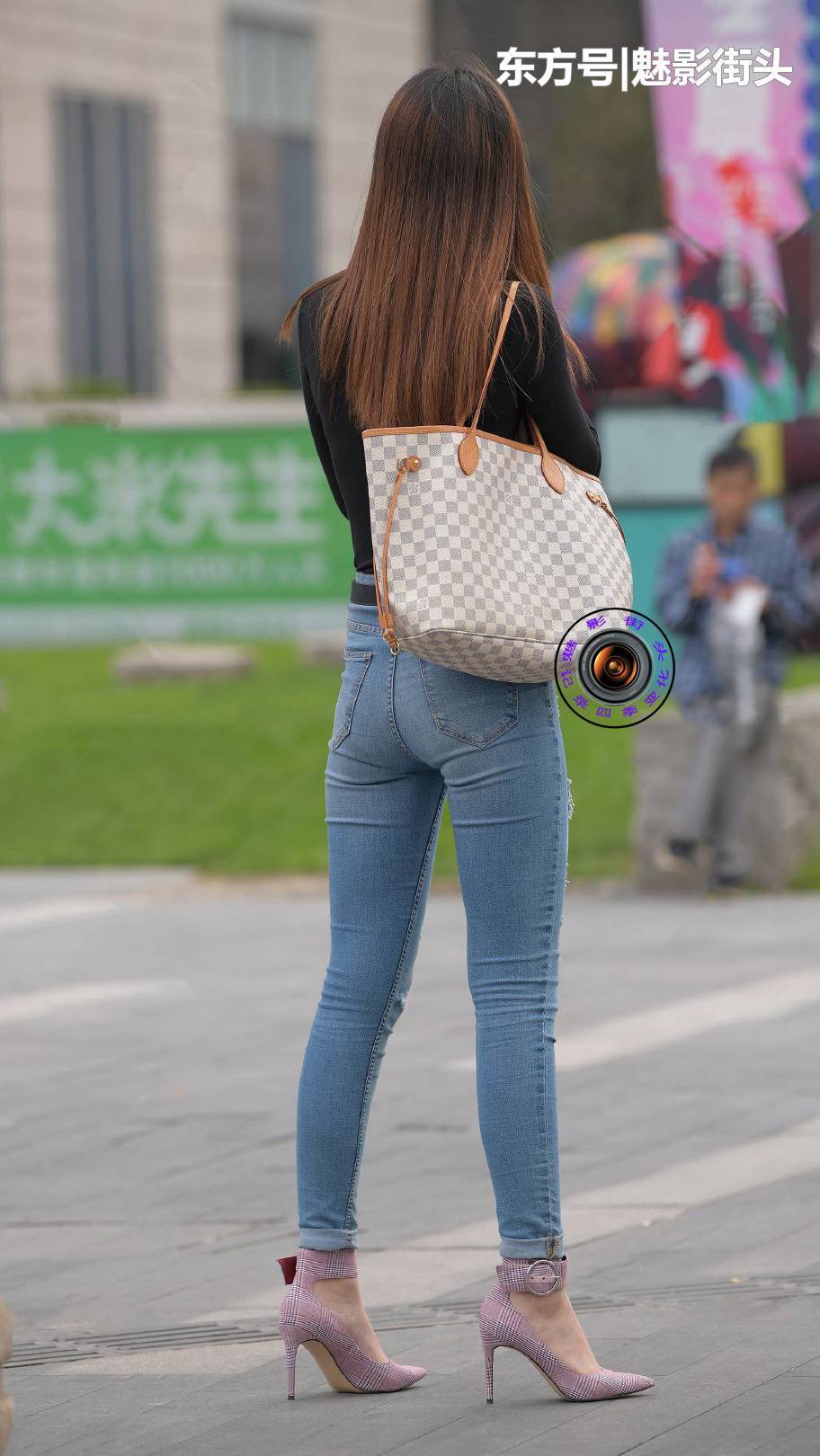  [服饰]黑色紧身T恤搭配蓝色紧身牛仔裤，脚下的紫色高跟鞋时尚又好看