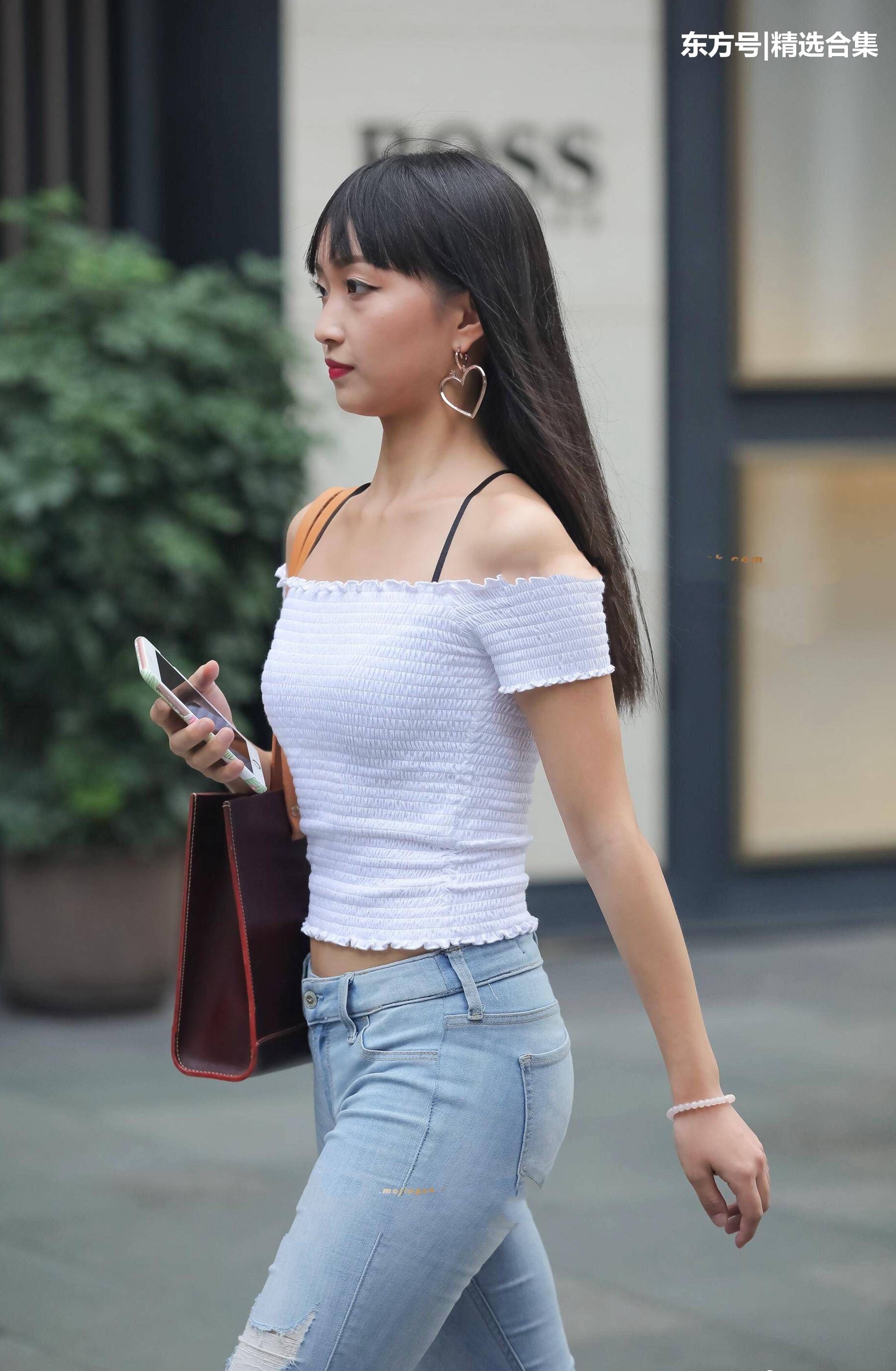 街拍美女:破洞紧身牛仔裤搭配白色漏肩针织衫，很素雅的小姐姐