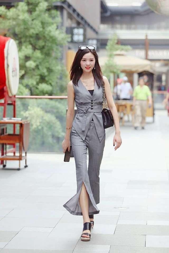 展现:街拍:美女化了漂亮的妆,吊带背心搭配阔腿裤,充分展现美丽大气感
