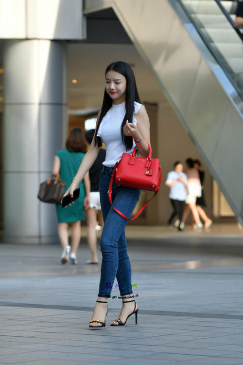 路人街拍，小姐姐紧身牛仔裤搭配白色无袖上衣，简单时尚的美！