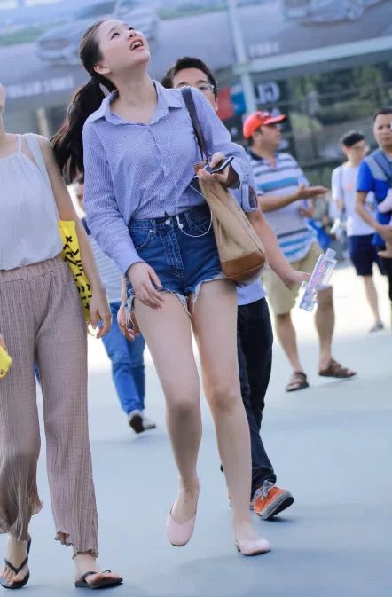 小姐姐牛仔短裤尽显青春活力，一直抬着头看，到底会掉下来什么呢