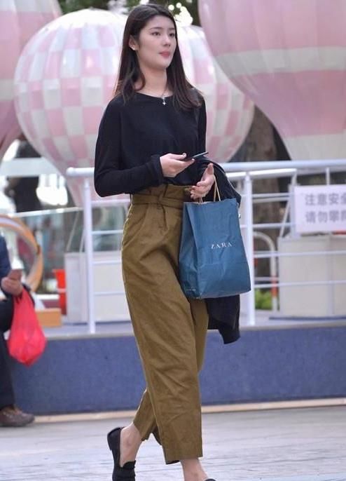  美女：街拍：身材高挑的美女，一件黑色上衣配棕色裤子，时尚活力气质