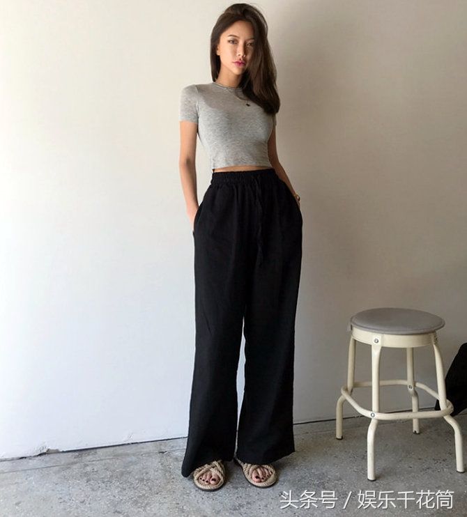 模特一袭灰色T恤配黑色阔腿裤简约时尚，气质清冷不苟言笑