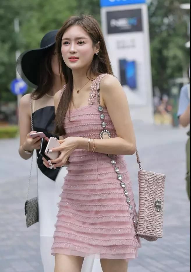 街拍：长得漂亮穿吊带粉群长腿苗条性感俏丽的女神