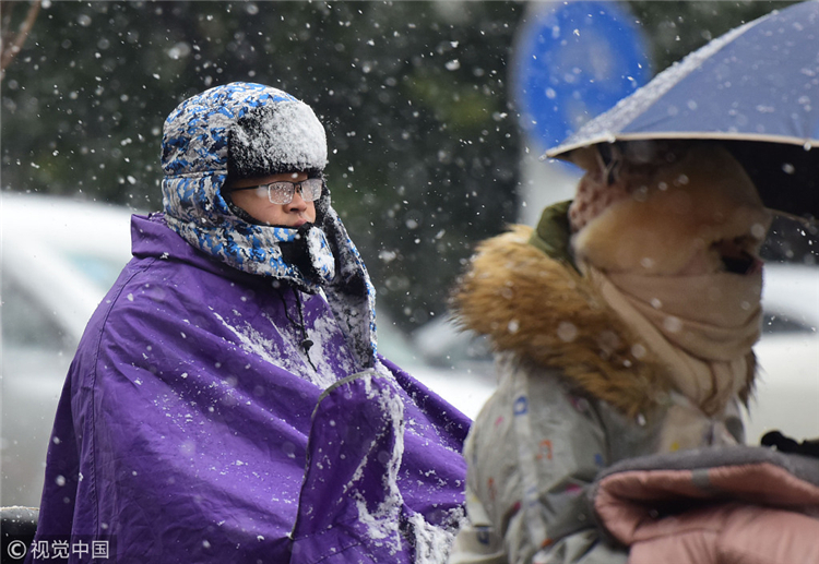 全国多地迎降雪 市民风雪中出行