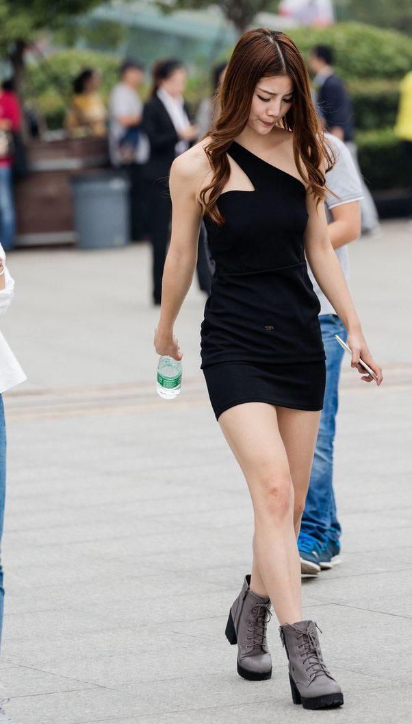 街拍:紧身短裙露肩装的美女很是吸人眼球，后面男子看得两眼发愣