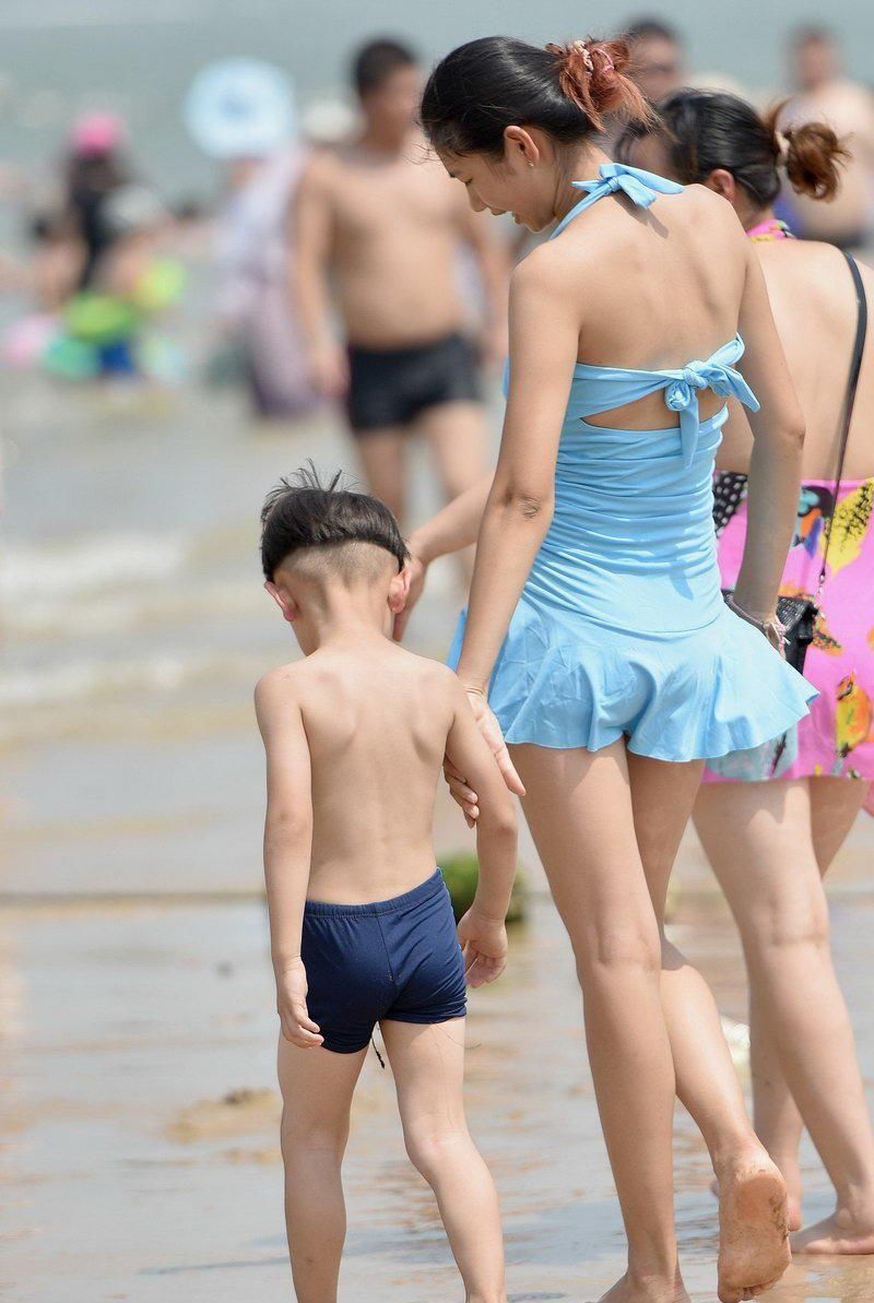 夏季海边实拍的吊带连体泳装美女，看起来很有范儿