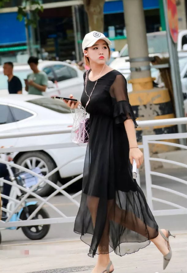街拍头戴遮阳帽身穿黑色薄纱连衣裙的美女小姐姐