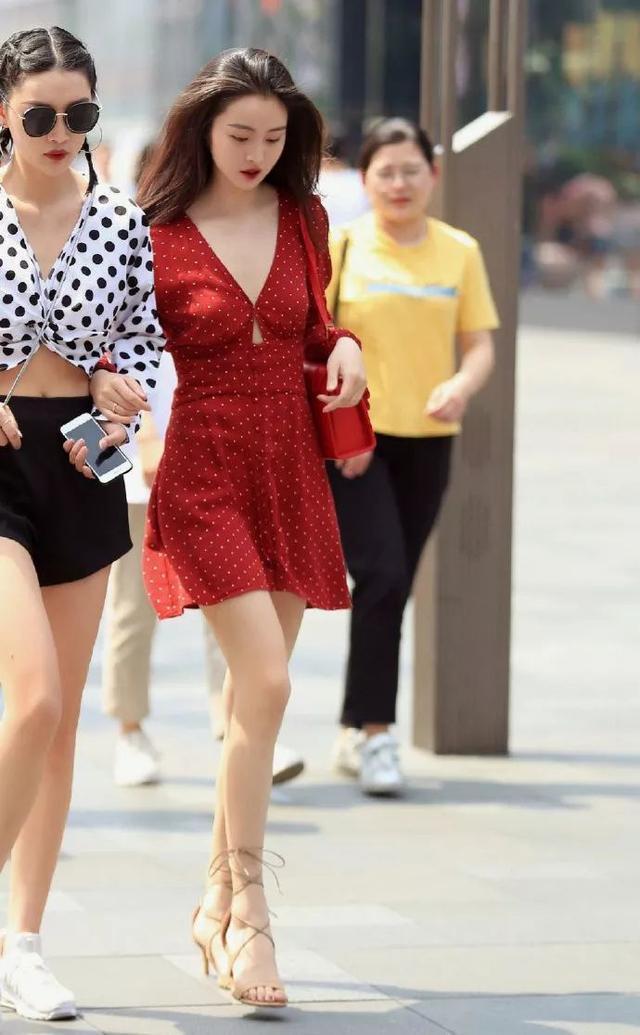 「优雅」街拍:小姐姐身穿白色的背心搭配上一条半裙,优雅的展示出美丽的双腿