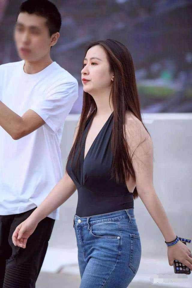 街拍：小姐姐穿搭白色紧身上衣，凸显丰满的上围，美丽优雅