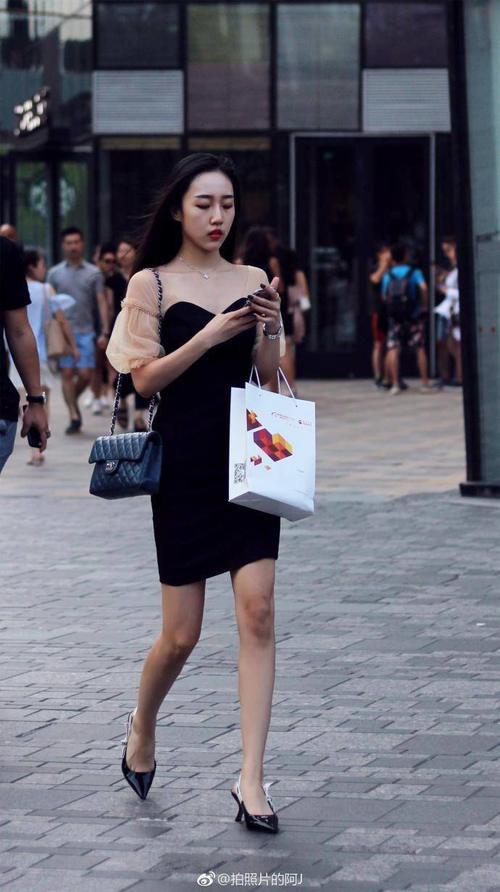 路人街拍，夏季最流行的就是小黑裙了，小姐姐诶穿上后非常的迷人