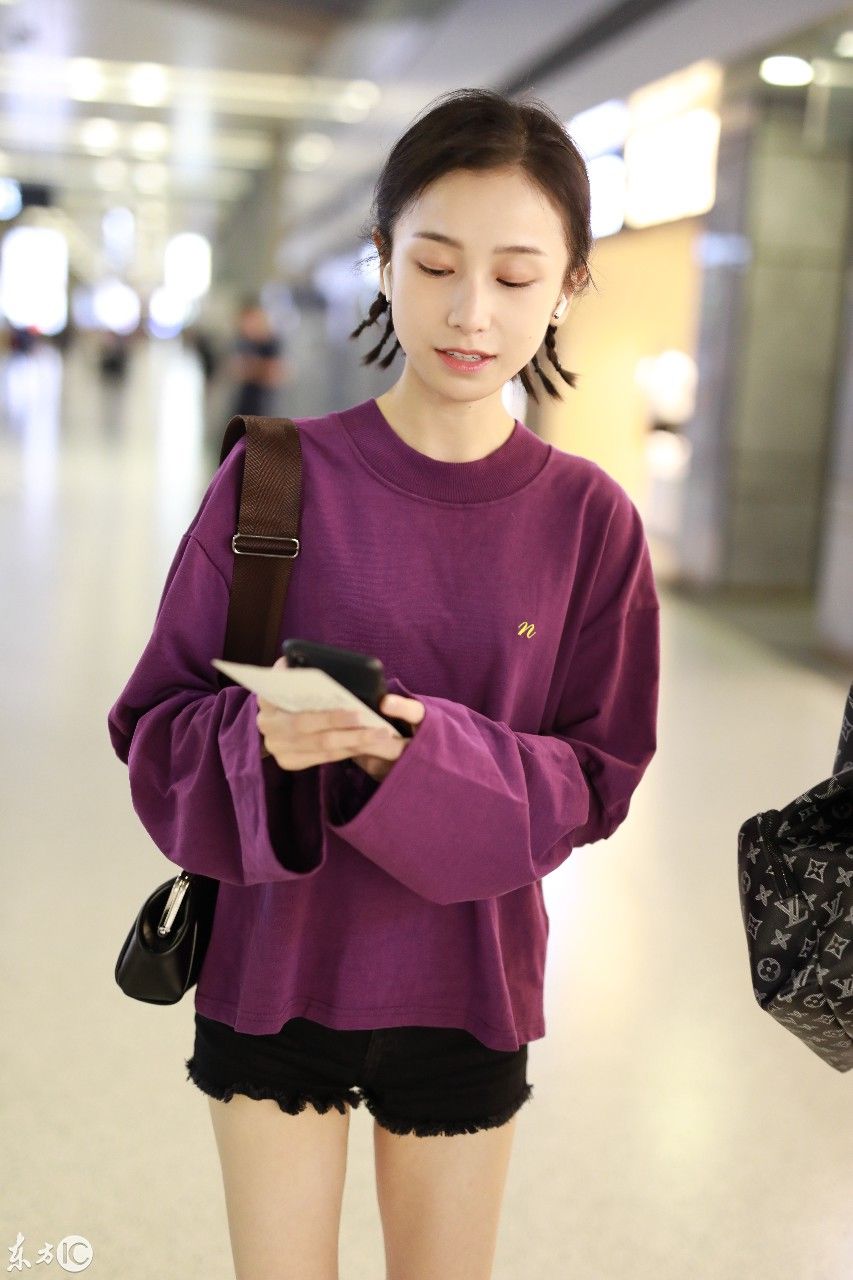 姜梓新穿紫色卫衣搭配黑短裤现身机场，皮肤白皙面带微笑大秀美腿