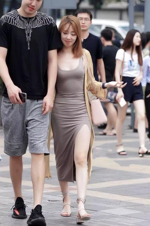街拍：穿开叉裙露着美腿，和男友逛街的漂亮美女
