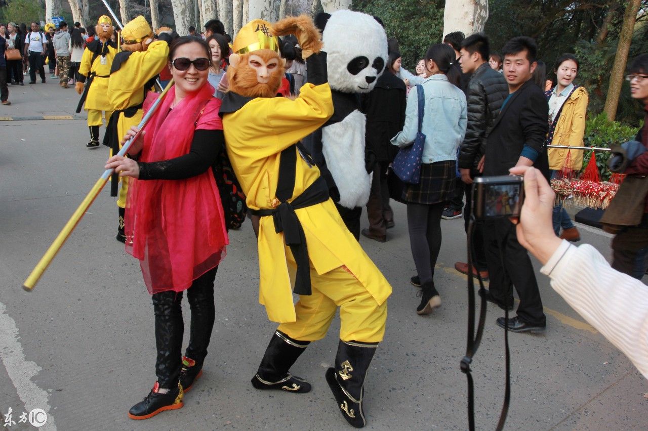 武汉大学樱花与游客，还有打扮成孙悟空的形象