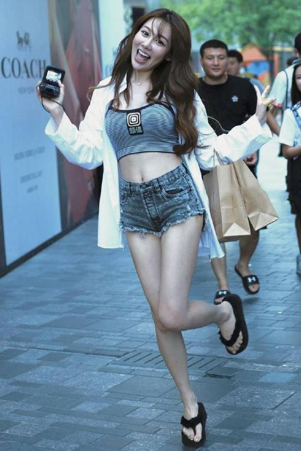 街拍:活泼可爱的小姐姐,穿毛边热裤还不断高抬美腿,显腿长?