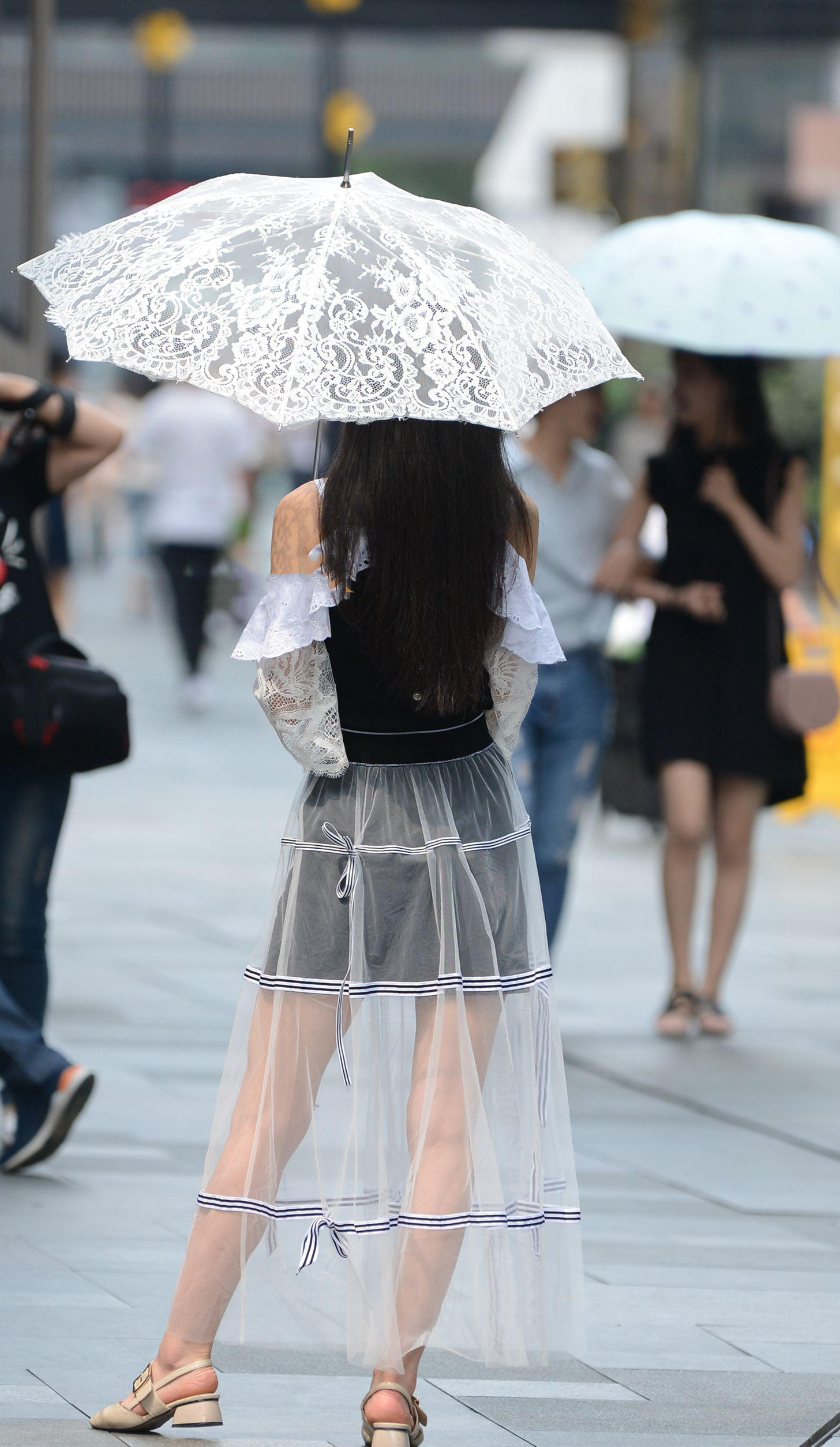 小姐姐穿着轻纱长裙，仿若纯纯少女，手持纯白镂花伞清纯妩媚