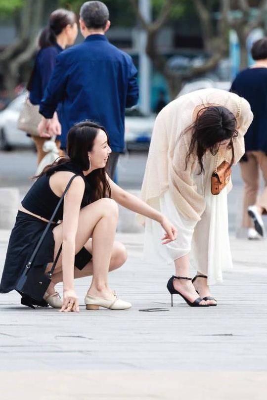 俏皮小姐姐嫌弃高跟鞋太高，与闺蜜当街换鞋，露出精美小脚丫