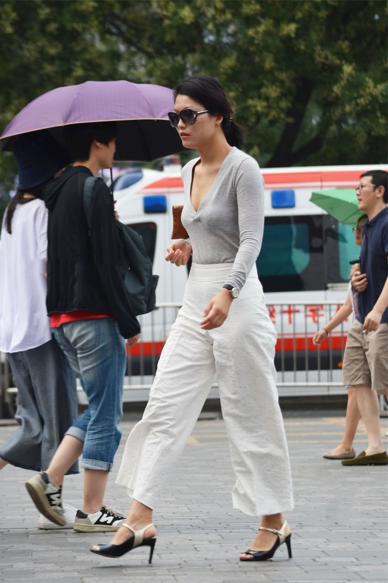 气质小阿姨紧身T恤裹出丰腴线条，手拿包包的姿态展现霸道女神范